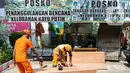 Petugas PPSU menyelesaikan pembuatan peti jenazah di Kantor Kelurahan Kayu Putih, Jakarta, Selasa, (6/7/2021). Kelurahan Kayu Putih berinisiatif membuat peti jenazah dilatar belakangi warganya yang terkendala ketersediaan peti saat angka kematian COVID-19 meningkat. (Liputan6.com/Faizal Fanani)