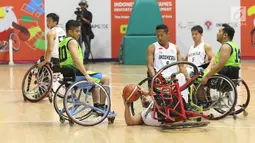 Pebasket difable Indonesia, Kasep Ayatulloh terjatuh saat berebut bola dengan pemain Malaysia pada laga Indonesia Para Games Invitational Tournament 2018 di Hall A Senayan, Jakarta, Minggu (1/7). Indonesia unggul 54-53. (Liputan6.com/Helmi Fithriansyah)