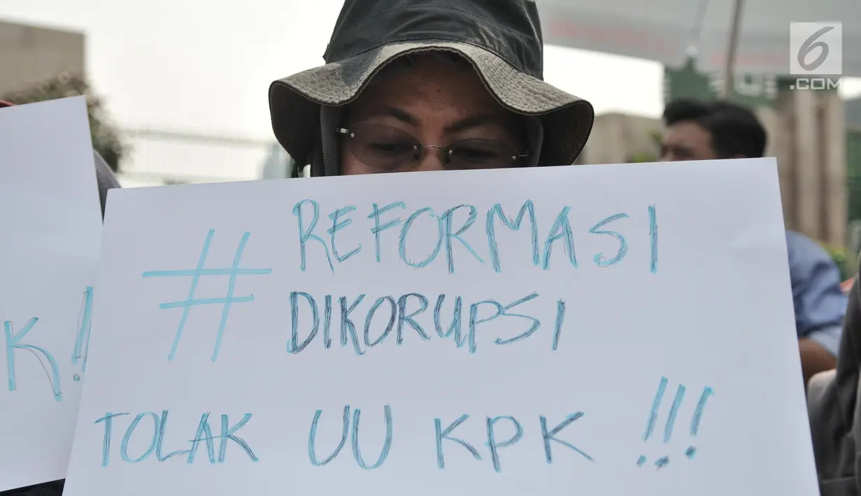 Massa yang tergabung dalam Koalisi Masyarakat Menyelamatkan KPK membentangkan poster saat aksi menolak UU KPK di Gedung DPR, Jakarta, Selasa (17/9/2019). Dalam aksinya massa membawa poster bertuliskan kekecewaan terhadap Jokowi dan DPR karena mengesahkan UU KPK. (merdeka.com/Iqbal S. Nugroho)