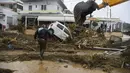 Seorang pria melintasi jalan yang terendam banjir menyusul badai petir yang hebat, di desa Agia Pelagia, di pulau Kreta, Yunani, Sabtu (15/10/2022). Dilaporkan setidaknya satu orang tewas dan lainnya hilang setelah banjir bandang yang parah. (AP Photo/Harry Nakos)