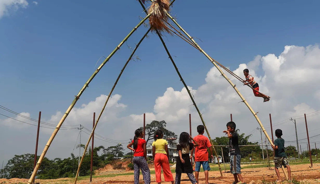Anak-anak bermain di ayunan khas negara Nepal di Lalitpur pinggiran kota Kathmandu, Nepal (26/9). Ayunan yang dikenal dengan sebutan 'Dashain Ping' ini bisa dimainkan orang-orang dari segala usia. (AFP Photo/Prakash Mathema)