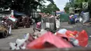 Petugas pengangkut sampah melintas di depan proyek Fasilitas Pengelolahan Sampah Terpadu atau Intermediate Treatment Facility (ITF) Sunter, Jakarta, Selasa (12/2). ITF Sunter ditargetkan beroperasi pada 2021. (Merdeka.com/Iqbal Nugroho)