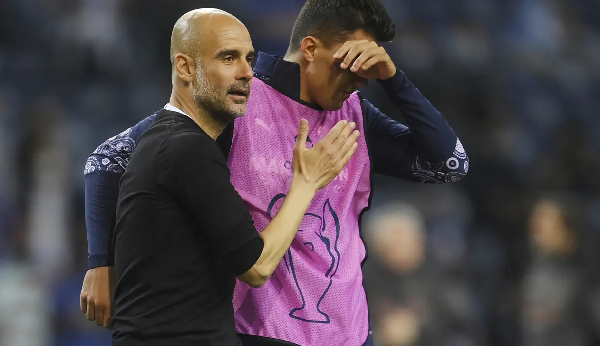 Pelatih Manchester City, Pep Guardiola memberi semangat pemainnya Rodrigo usai pertandingan melawan Chelsea pada babak final Liga Champions di Stadion Dragao, Portugal (30/5/2021). Man City gagal untuk mengukir sejarah dengan menjuarai Liga Champions untuk pertama kalinya. (David Ramos/Pool via AP)