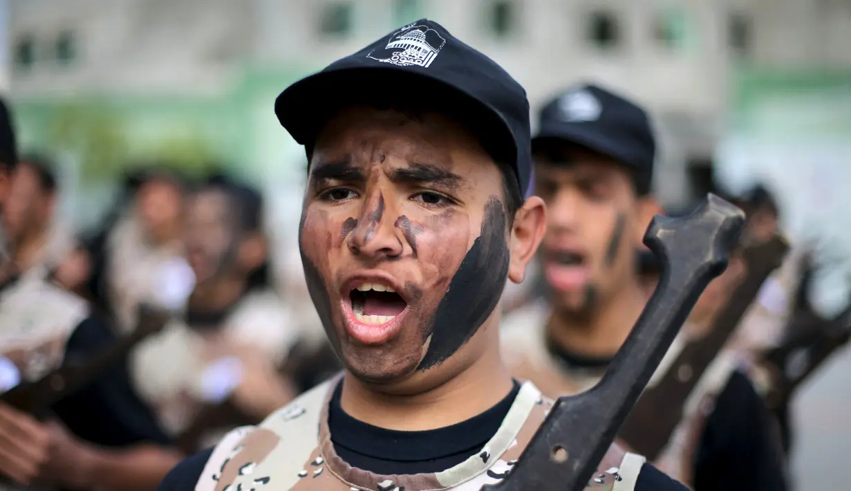 Pelajar berteriak selama latihan militer di sebuah sekolah, Rafah, Jalur Gaza, Senin (28/3). Para pelajar dengan semangat diajarkan beberapa gerakan militer. (REUTERS / Ibraheem Abu Mustafa)