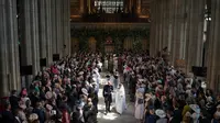 Pangeran Harry dan istri, Meghan Markle berjalan meninggalakan altar usai prosesi pernikahan mereka di Kastil Windsor, Inggris, Sabtu (19/5). Warga Inggris bersuka cita menyambut pernikahan Pangeran Harry dengan Meghan Markle. (Dominic Lipinski/POOL/AFP)