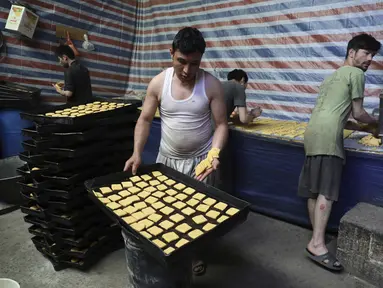 Pembuat roti menyiapkan penganan manis di toko roti tradisional menjelang bulan puasa Ramadan mendatang, di Kabul, Afghanistan, pada 7 April 2021. Sebentar lagi, umat Muslim di seluruh dunia akan menyambut bulan Ramadan.  (AP Photo / Rahmat Gul)
