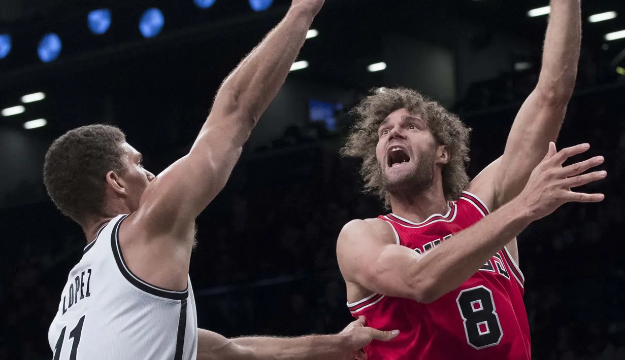 Chicago Bulls center, Robin Lopez #8 berusaha melewati hadangan Brooklyn Nets center, Brook Lopez #11 pada laga NBA basketball game, (31/10/2016) Bulls menang 118-88. (AP/Mary Altaffer)