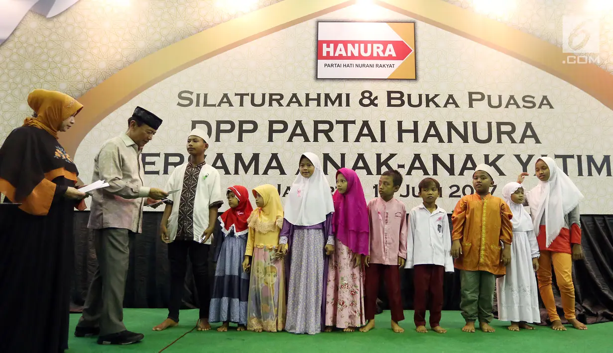 Ketua Dewan Pembina Hanura Wiranto memberikan santunan saat menghadiri acara Buka Bersama Partai Hanura di Jakarta, Jumat (16/6). Acara buka bersama ini sebagai silaturahmi Partai Hanura dan dihadiri ribuan anak Yatim. (Liputan6.com/Johan Tallo)