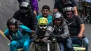 Para peserta menuruni bukit menggunakan kendaraan buatan mereka sendiri selama festival kendaraan luncur dengan nama Car Festival ke 29 di Medellin, Kolombia pada 18 November 2018. (Photo by JOAQUIN SARMIENTO / AFP)