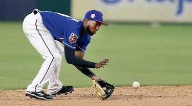 Pemain Texas Rangers, Jurickson Profar (19) berusaha menangkap bola pukulan grounder Cincinnati Reds, Tony Cruz selama inning ketujuh pertandingan bisbol pramusim di Arlington, Texas (26/3). Texas menang 6-5. (AP Photo/Brandon Wade)