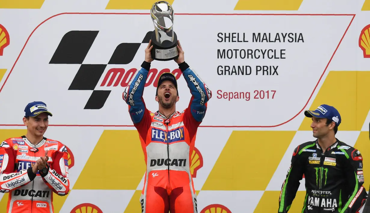 Pebalap Ducati, Andrea Dovizioso, melakukan selebrasi usai menjuarai balapan MotoGP Malaysia di Sirkuit Sepang, Minggu (29/10/2017). Dovizioso finis pertama dengan catatan waktu 44 menit 51,497 detik. (AFP/Mohd Rasfan)