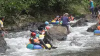 Para pelancong saat mencoba sensasi arung jeram Longalo River Tubing Bonebol (Arfandi/Liputan6.com)