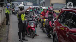 Anggota polisi mengatur lalu lintas saat ganjil genap di kawasan Jalan D.I Panjaitan, Jakarta, Senin (6/6/2022). Perluasan ganjil genap juga sesuai dengan Pergub DKI Jakarta Nomor 88 Tahun 2019. (Liputan6.com/Faizal Fanani)