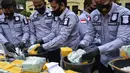 Sejumlah petugas kepolisian saat memusnahkan barang bukti sabu dan pil ekstasi saat konferensi pers di Mabes Polri di Banda Aceh (15/12/2020). Sekitar 469 kilogram sabu dan 138.000 pil ekstasi dimusnahkan. (AFP/Chaideer Mahyuddin)