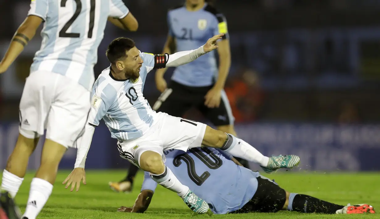 Pemain Argentina, Lionel Messi terjatuh saat berebut bola dengan pemain Uruguay, Alvaro Gonzalez pada laga kualifikasi Piala Dunia 2018 di Montevideo, Uruguay, (31/8/2017). Argentina bermain imbang 0-0. (AP/Natacha Pisarenko)