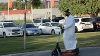 Seorang warga menggunakan skuter listrik di wilayah Kota Doha, sebagai pusat berlangsungnya Piala Dunia 2022. (Bola.com/ Ade Yusuf Satria)