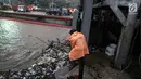 Petugas membersihkan sampah yang menyangkut di Pintu Air Manggarai, Jakarta, Senin (5/2). Hal itu dilakukan agar tumpukan sampah tidak menutupi arus air. (Liputan6.com/Faizal Fanani)