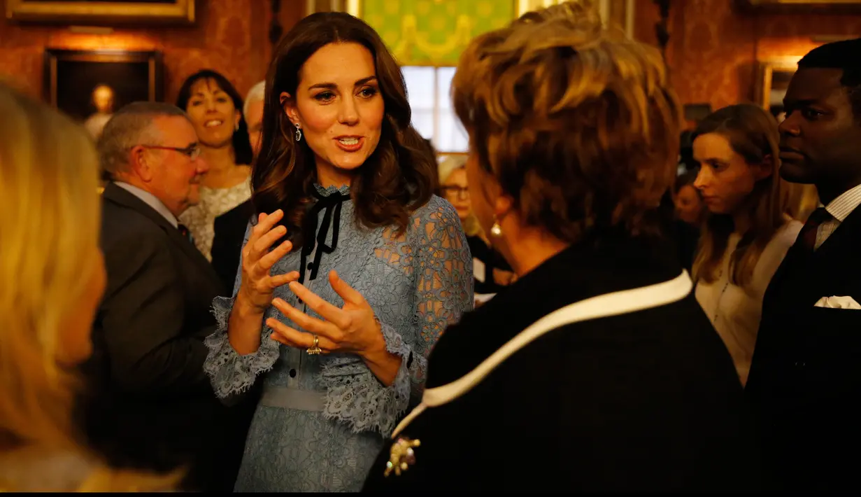 Kate Middleton berbincang dengan tamu saat menghadiri perayaan Hari Kesehatan Mental Sedunia di Istana Buckingham, London, Selasa (10/10). Kate tampil di depan publik, pertama kalinya sejak pengumuman kehamilan anak ketiga. (Heathcliff O'Malley/pool AP)
