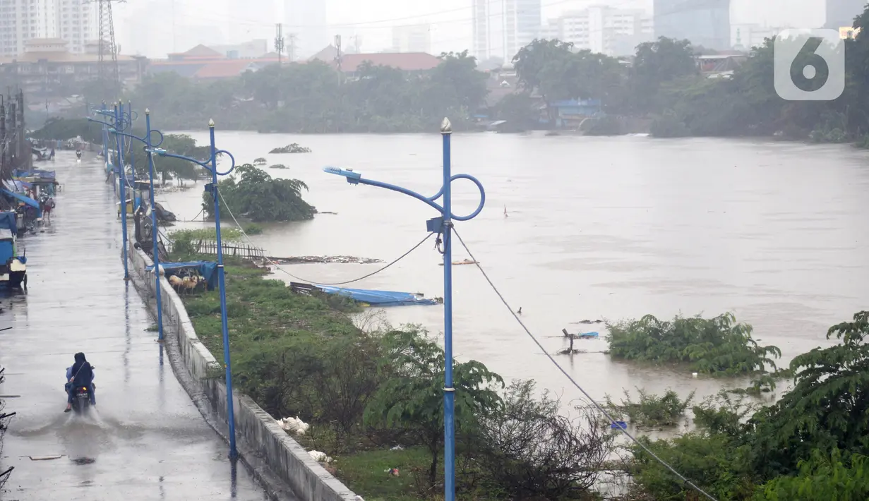 Pengendara melintas di jalan inspeksi Banjir Kanal Barat di Kawasan Tanah Abang, Jakarta, Rabu (1/1/2020). Hujan yang mengguyur Jakarta sejak Selasa sore (31/12/2019) mengakibatkan debit air Banjir Kanal Barat tinggi dan hampir meluap. (Liputan6.com/Helmi Fithriansyah)