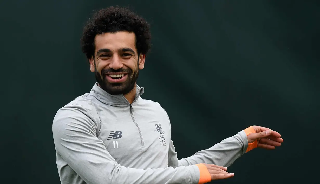 Penyerang Liverpool asal Mesir Mohamed Salah tersenyum saat melakukan pemanasan di kompleks pelatihan Melwood tim di Liverpool, Inggris barat laut, (23/4). Liverpool akan bertanding melawan wakil Italia, AS Roma di stadion Anfield. (AFP Photo/Paul Ellis)
