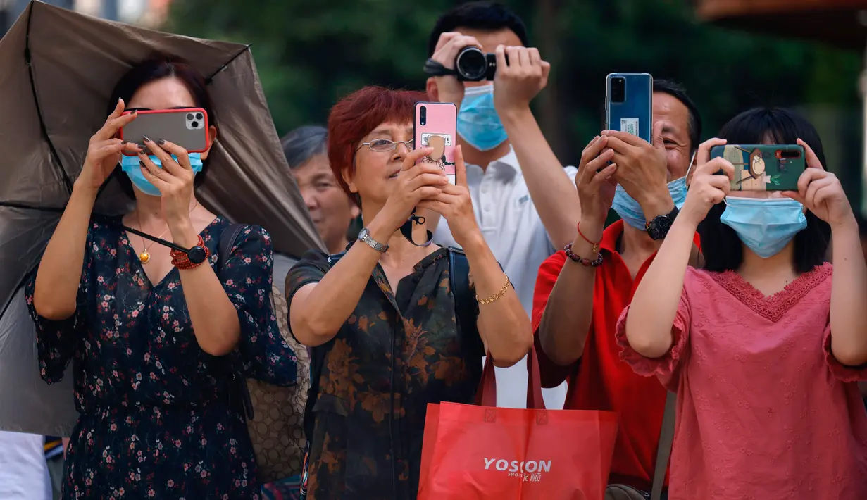 Warga mengambil foto dan video ketika otoritas Cina bersiap memasuki Konsulat Amerika Serikat (AS) di Chengdu, Senin (27/7/2020). Bendera Amerika Serikat di Konsulat AS Chengdu diturunkan Senin (27/7), menandai ditutupnya kantor perwakilan Negeri Paman Sam di kota itu. (AP Photo/Ng Han Guan)
