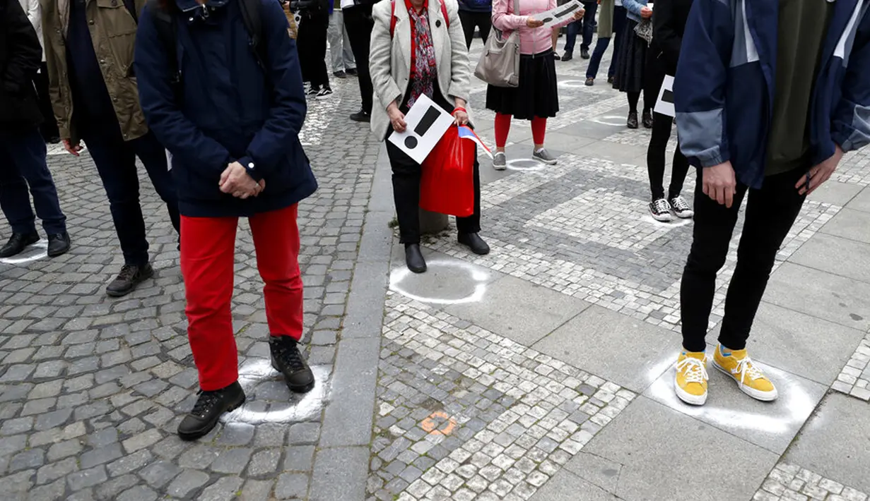 Warga berusaha jaga jarak saat berdemonstrasi di Praha, Republik Ceko, Kamis (29/4/2021). Ribuan warga berunjuk rasa menentang Presiden Milos Zeman dan menuduhnya melakukan pengkhianatan atas sikap pro Rusia pada dugaan partisipasi mata-mata Rusia dalam ledakan di Ceko. (AP Photo/Petr David Josek)