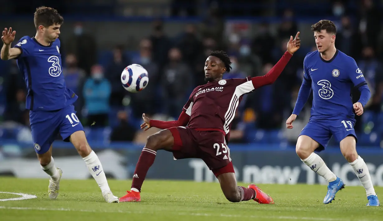 Gelandang Leicester City, Wilfred Ndidi (tengah) berebut bola dengan gelandang Chelsea, Christian Pulisic dalam laga pekan ke-37 Liga Inggris di Stamford Bridge, London, Rabu (19/5/2021) dinihari WIB. Chelsea menang 2-1 saat menjamu Leicester City. (Peter Cziiborra/Pool via AP)