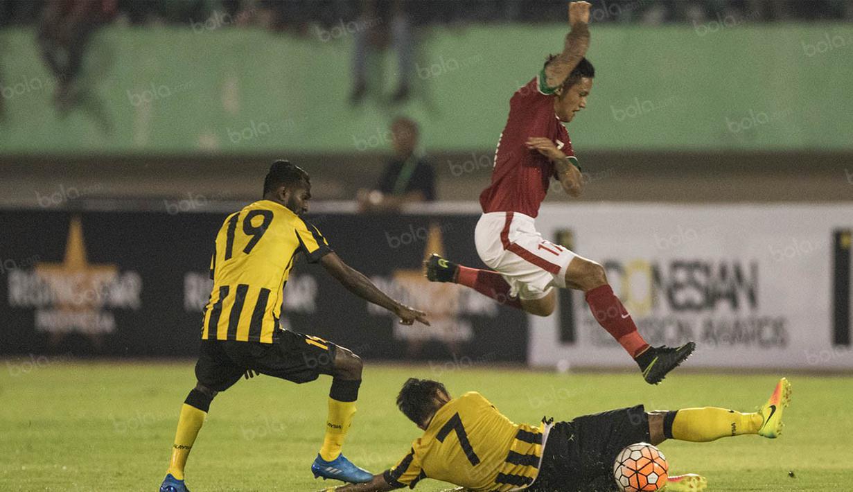 Penyerang Indonesia, Irfan Bachdim, melewati hadangan gelandang Malaysia, Mohamad Irfan. Pertandingan persahabatan ini dalam rangka persiapan jelang Piala AFF yang akan bergulur pada November mendatang. (Bola.com/Vitalis Yogi Trisna)