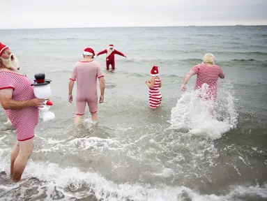 Sejumlah peserta Kongres Santa Claus Dunia 2015 berenang di pantai Bellevue di Copenhagen, Denmark, Minggu (21/7/2015). (REUTERS/Scanpix Denmark/Erik Refner)