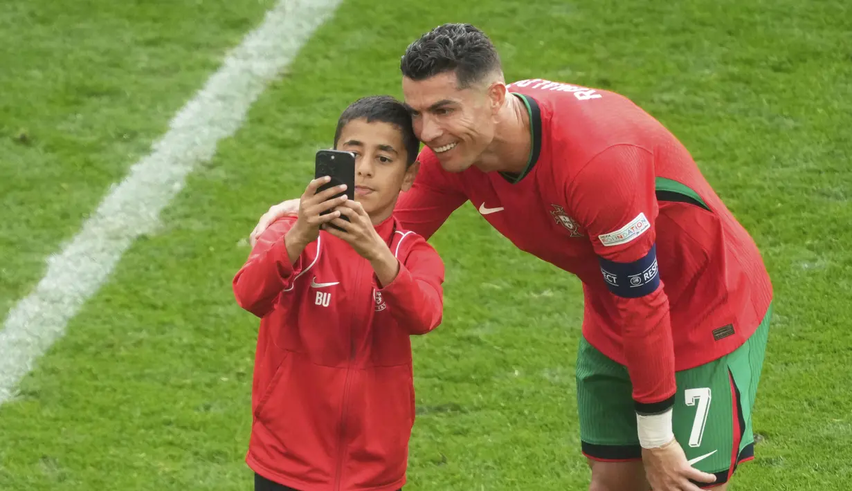 Salah satunya adalah seorang bocah yang berhasil menembus lapangan dan mengelabui petugas keamanan hingga sempat berfoto bersama idolanya.  (Foto AP/Michael Probst)