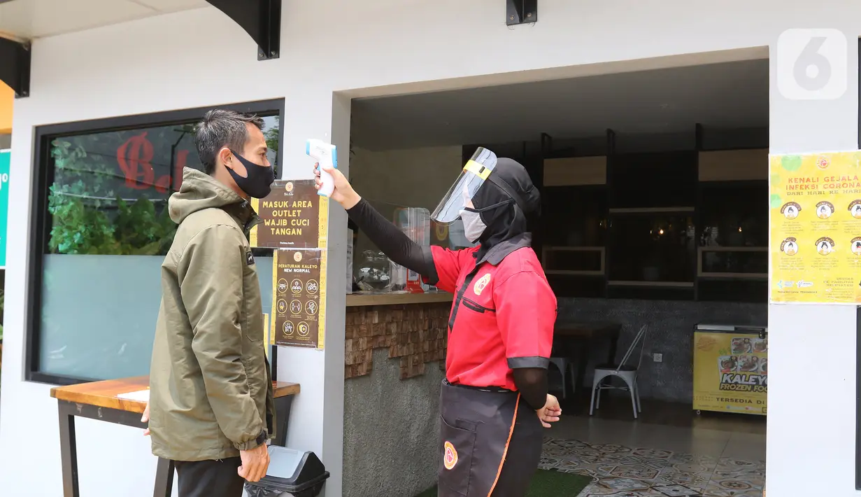 Petugas mengukur suhu pengunjung sebelum memasuki restoran Bebek Kaleyo, Kemanggisan, Jakarta, Senin (12/10/2020). Pada penerapan kembali PSBB Transisi Jakarta, restoran dan cafe diperbolehkan melakukan pelayanan makan di tempat dengan protokol kesehatan yang ketat. (Liputan6.com/Herman Zakharia)