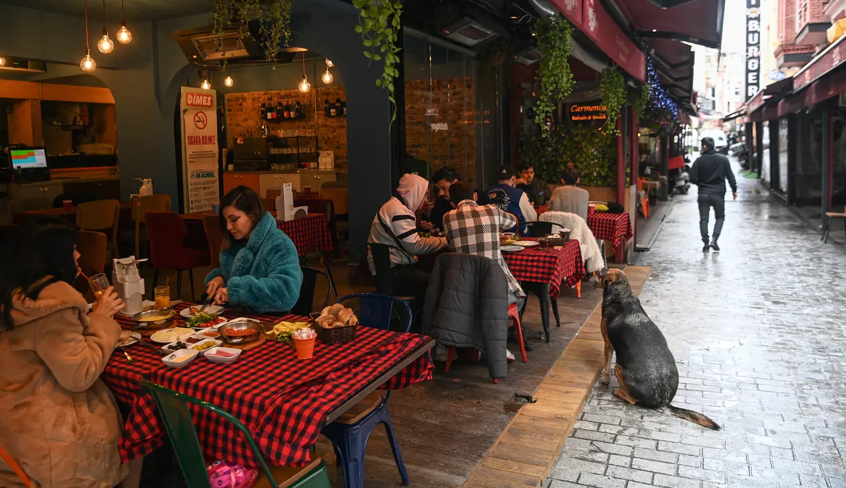 Pelanggan makan di sebuah restoran di Besiktas, Istanbul, setelah negera tersebut melonggarkan pembatasan, Selasa (2/3/2021). Pemerintah Turki menutup semua restoran untuk makan di tempat pada November dan memberlakukan penguncian wilayah pada akhir pekan secara nasional. (Ozan KOSE/AFP)