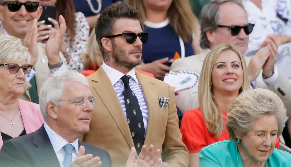 Mantan pesepak bola Inggris, David Beckham duduk dekat mantan Perdana Menteri Inggris John Major dan istrinya Norma saat menyaksikan babak semifinal Grand Slam Wimbledon dari kursi penonton di area Royal Box, Centre Court All England Lawn Tennis and Croquet Club, Kamis (11/7/2019). (AP/Tim Ireland)
