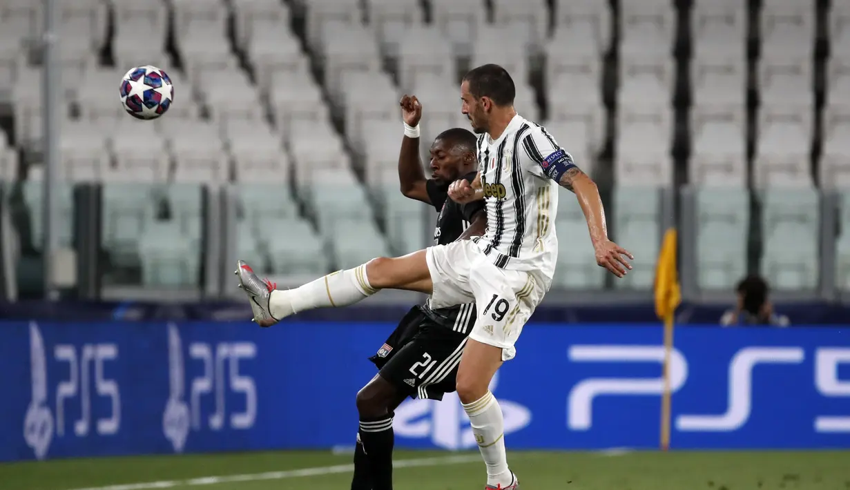 Bek Juventus, Leonardo Bonucci berebut bola dengan penyerang Lyon, Karl Toko Ekambi pada leg kedua babak 16 besar Liga Champions di Allianz stadium, Turin, Italia (7/8/2020). Juventus menang 2-1 atas Lyon, namun tersingkir dari Liga Champions setelah aggregat skor 2-2. (AP Photo/Antonio Calanni)