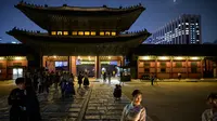 Gambar pada 4 Oktober 2019 memperlihatkan wisatawan saat kunjungan malam ke Istana Gyeongbokgung di pusat Seoul, Korea Selatan. Kunjungan malam tersedia pada minggu ketiga dan keempat setiap bulan mulai dari 26 April sampai 31 Oktober, kecuali pada bulan Agustus. (Photo by Ed JONES / AFP)