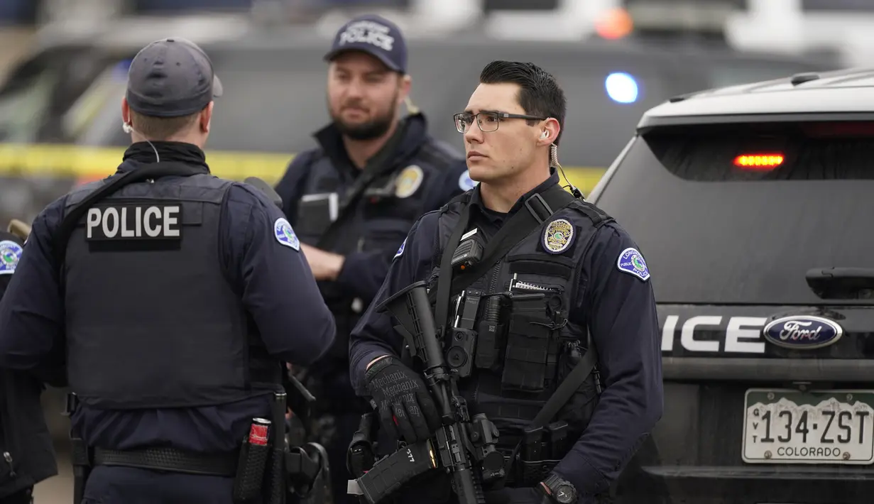 Polisi berjaga di tempat kejadian di luar toko kelontong King Soopers tempat penembakan terjadi di Boulder, Colorado (22/3/2021). Aksi penembakan tersebut rupanya menargetkan antrean vaksinasi yang tengah dilakukan di pusat perbelanjaan tersebut. (AP Photo/David Zalubowski)