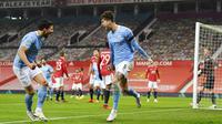 Pemain Manchester City, John Stones, melakukan selebrasi usai mencetak gol ke gawang Manchester United pada laga Piala Liga Inggris di Stadion Old Trafford, Rabu (6/1/2021). City menang dengan skor 2-0. (Shaun Botterill/Pool via AP)