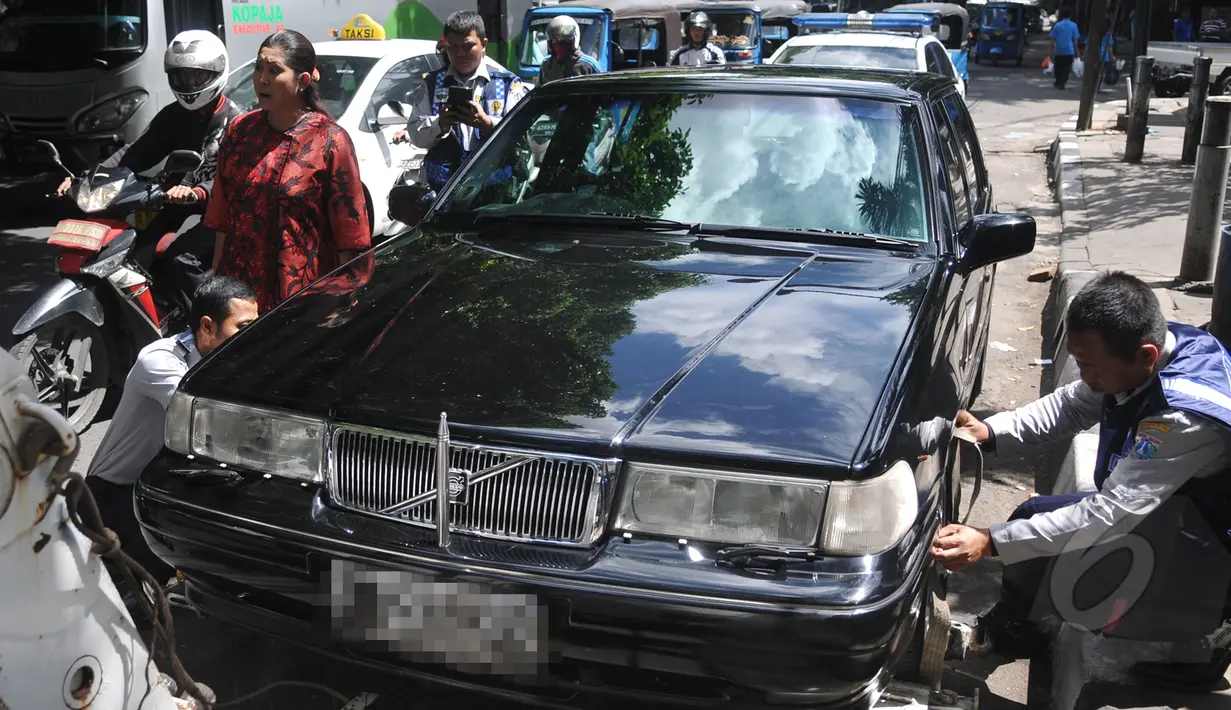 Sebuah mobil sedan berwarna hitam akan diderek oleh Dishub karena telah parkir liar di kawasan Cikini, Jakarta, Selasa (28/4/2015). (Liputan6.com/JohanTallo)