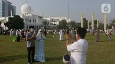 Umat muslim berswafoto usai melaksanakan shalat Idul Fitri 1442 H di Lapangan Masjid Agung Al Azhar, Jakarta, Kamis (13/5/2021). Ribuan umat muslim melaksanakan shalat Idul Fitri 1442 H di Lapangan Masjid Agung Al Azhar dengan menerapkan protokol kesehatan ketat. (Liputan6..com/Helmi Fithriansyah)