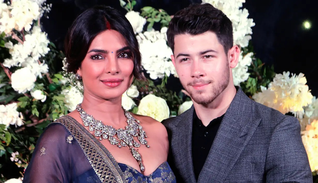 Pasangan aktris Bollywood Priyanka Chopra dan musisi Nick Jonas berpose untuk resepsi kedua pernikahan mereka di Mumbai, India, Rabu (19/12). Nick dan Priyanka sengaja membuat pesta khusus untuk berbagi kebahagiaan dengan awak media. (AP/Rajanish Kakade)