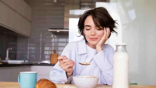 Ilustrasi seseorang berada di meja makan dengan smartphone diletakkan jauh, menggambarkan upaya mengurangi mental fatigue melalui area bebas gadget.