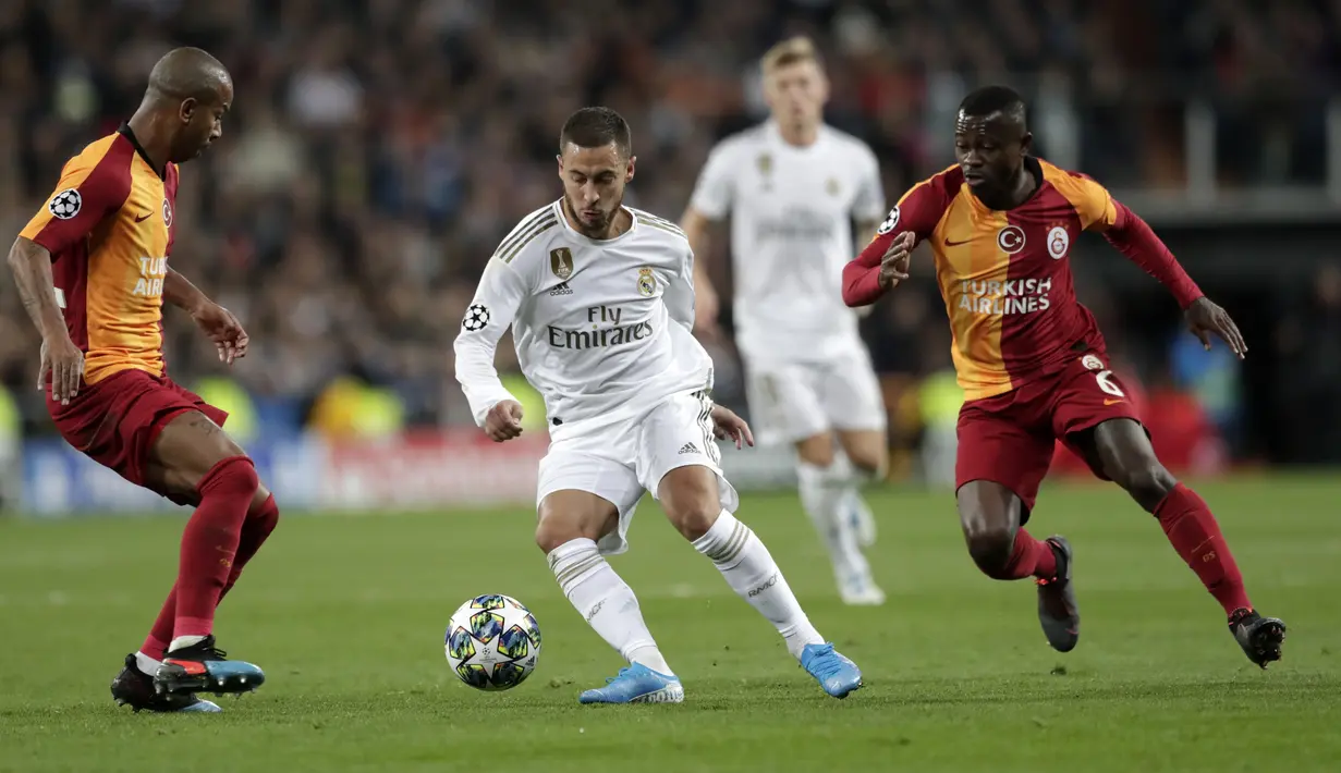 Gelandang Real Madrid, Eden Hazard berusaha melewati dua pemain Galatasaray pada pertandingan Grup A Liga Champions di stadion Santiago Bernabeu, Spanyol (6/11/2019). Madrid menang telak 6-0 atas Galatasaray. (AP Photo/Bernat Armangue)