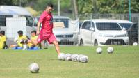 Javier Roca memberikan contoh tendangan bebas kepada pemain Arema FC. (Bola.com/Iwan Setiawan)