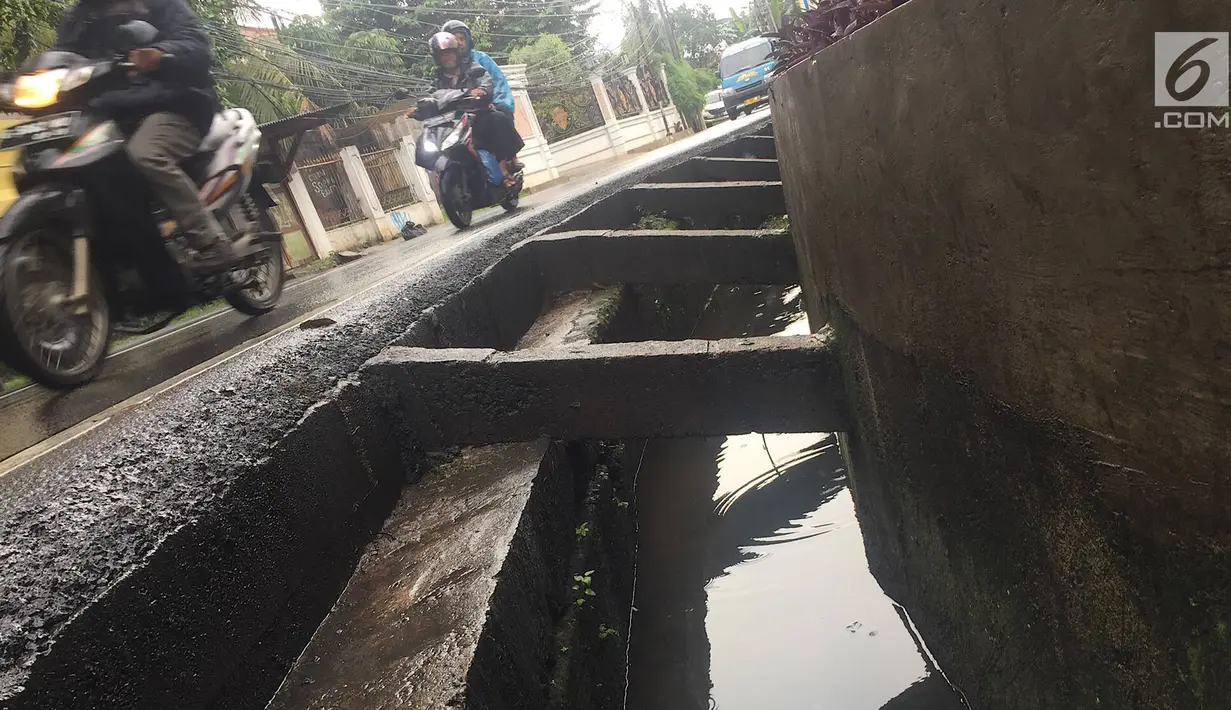 Pengendara melintas di samping selokan tanpa penutup di Jalan Mohammad Kahfi I, Jagakarsa, Jakarta, Selasa (22/1). Selain membahayakan pejalan kaki, kondisi tersebut juga berbahaya bagi pengendara terutama saat malam hari. (Liputan6.com/Immanuel Antonius)