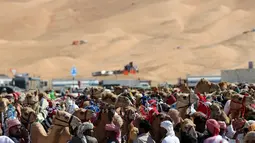 Para pemilik mempersiapkan unta mereka untuk mengikuti lomba balap Liwa 2018 Moreeb Dune Festival di gurun Liwa, Abu Dhabi (26/12). (AFP Photo/Karim Sahib)