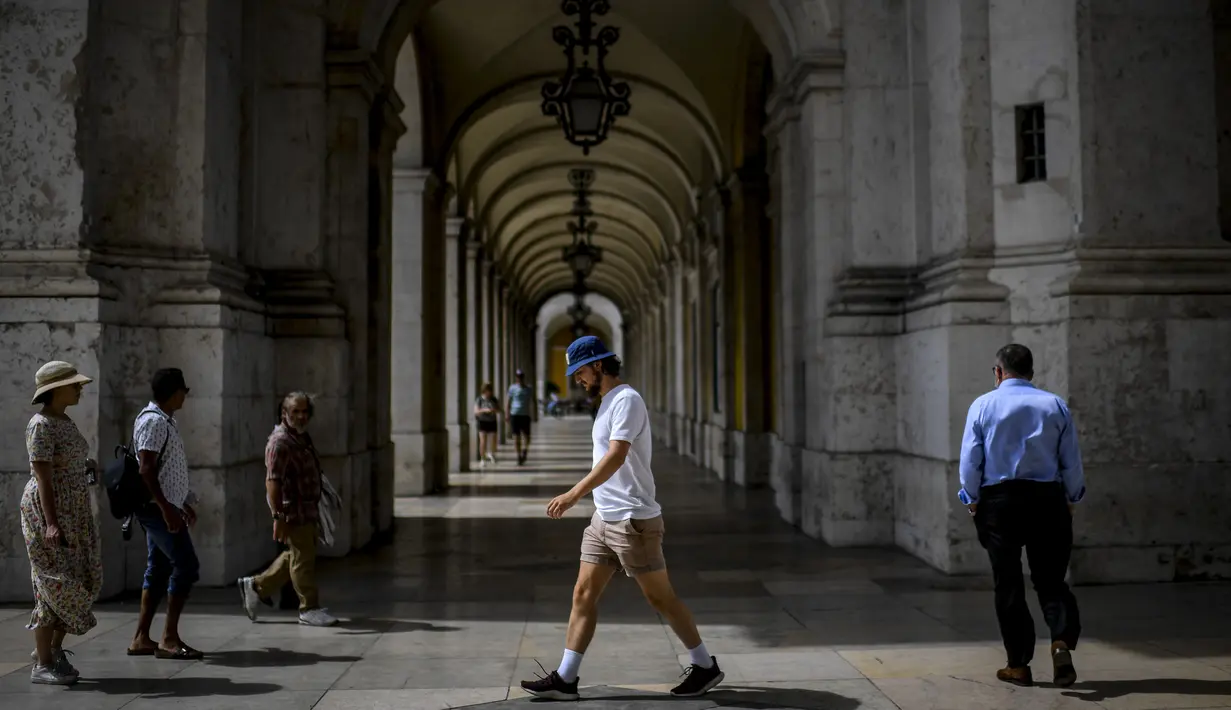 Orang-orang berjalan di pusat kota Lisbon, Portugal, Senin (13/9/2021). Portugal hari ini mengakhiri aturan wajib penggunaan masker di jalan-jalan. (PATRICIA DE MELO MOREIRA / AFP)