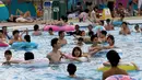 Pengunjung berada di kolam renang di sebuah taman hiburan di Tokyo, Jepang (19/7). Badan Meteorologi Jepang mengumumkan Jepang tengah, termasuk Tokyo, telah menyelesaikan musim hujan 'Tsuyu'.  (AFP Photo/Toshifumi Kitamura)