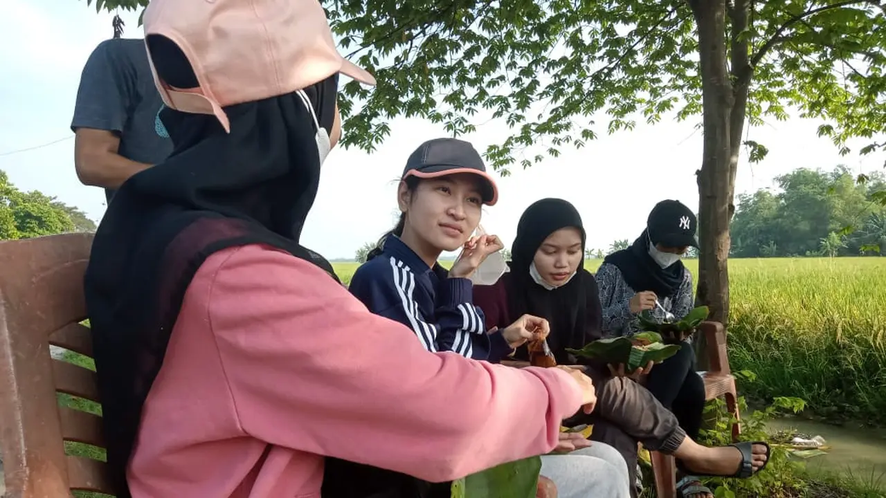 Dhira (20) menikmati sega ndoreng di pinggir sawah Desa Kendaldoyong Kecamatan Wonosalam Demak. Selasa,1/6/2021. (Foto: Liputan6.com/Kusfitria Marstyasih)