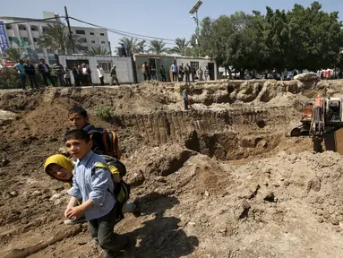 Sejumlah anak melihat excavator yang sedang melakukan penggalian, yang dipercaya oleh arkeolog merupakan bagian dari gereja Bizantium yang berusia sekitar 1.500 tahun lalu di kota Gaza, Senin (4/4/2016). (REUTERS/Mohammed Salem)