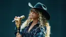 Paduan blazer flanel yang hadir dengan bordir terlihat kian unik saat dipadukan dengan topi koboi dan boots. [Foto: Instagram/ Beyonce]